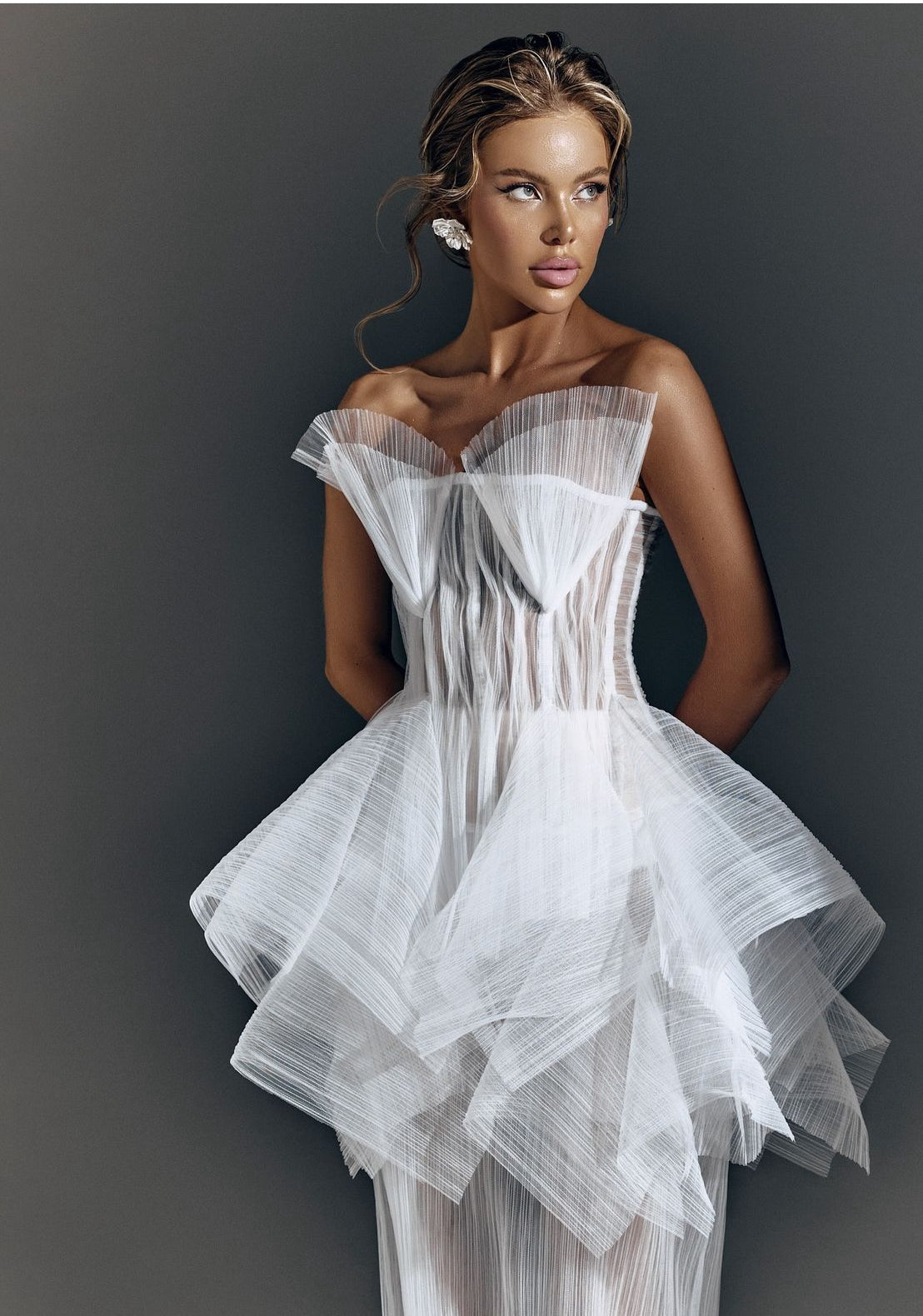 An elegant ball gown with a sweetheart neckline, adorned with delicate embroidery and a voluminous satin skirt, showcased on a hanger in a sunlit room.