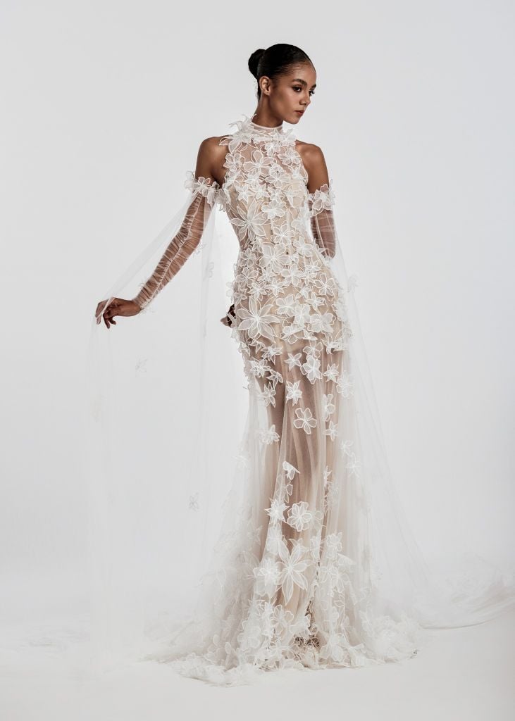 Model wearing a floral lace wedding dress against a white background